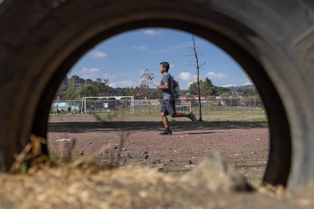 Young man running on a park of a poor town in mexico