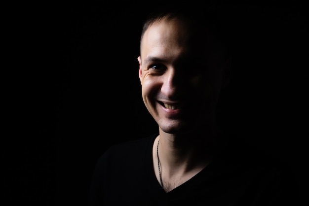 Young man's portrait. Close-up face against black background