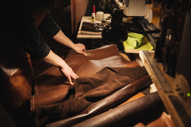 Young man shoemaker at footwear workshop.