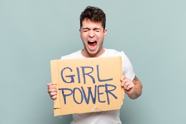 Young man shouting aggressively, looking very angry, frustrated, outraged or annoyed, screaming no