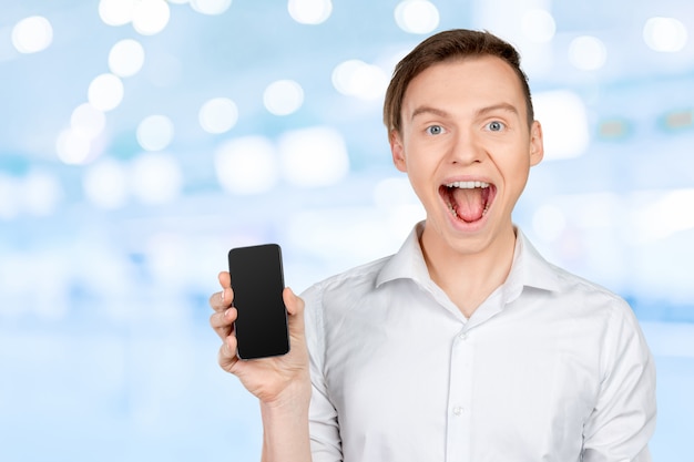 Young man showing a blank smart phone screen 