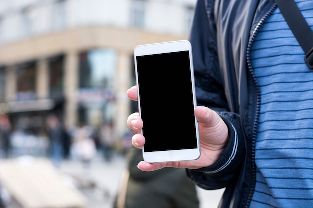 Young man showing a screen of his mobile phone