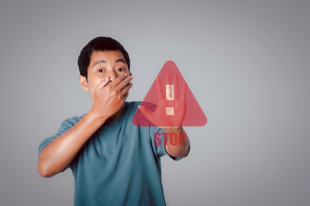 Young man showing stop gesture with stop sign virtual screen Warning and alert attention signs