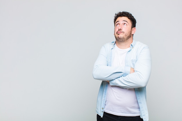 Young man shrugging, feeling confused and uncertain