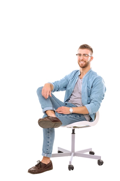 Young man sitting on the chair isolated over white background Startupper Young entrepreneur