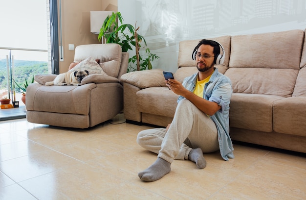 Young man sitting on the floor chatting on his phone