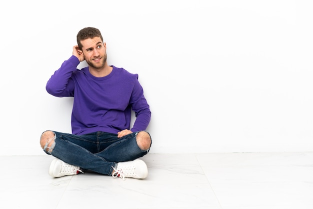 Young man sitting on the floor having doubts