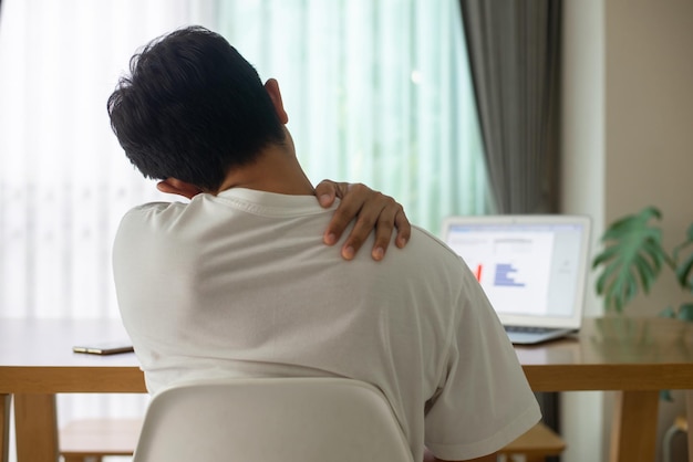 Young man sitting at his desk at home using a computer.