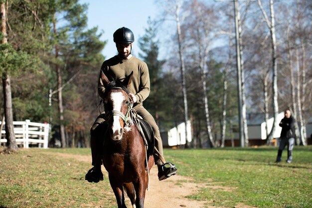 Photo young man sitting on a horse outdoors