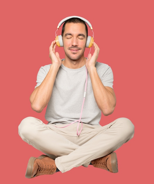 Young man in sitting position with a relaxation gesture