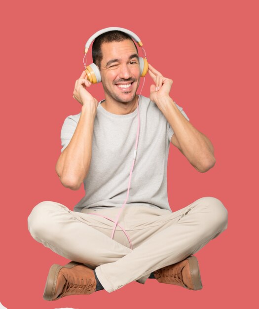 Young man in sitting position with a satisfaction gesture