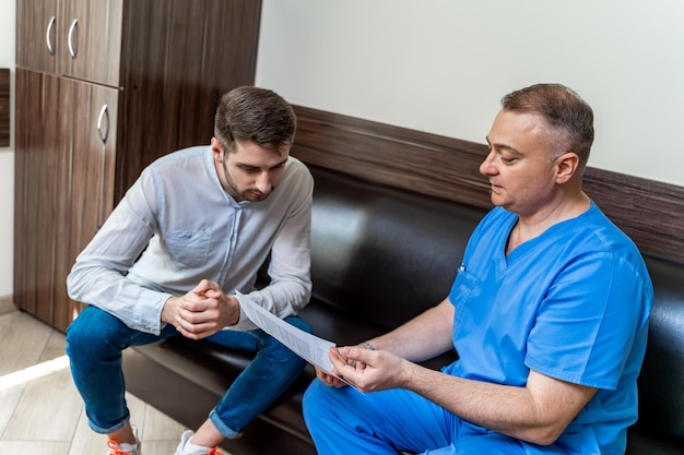 Young man sitting on sofa in the reception room at office Consultation at doctor s office