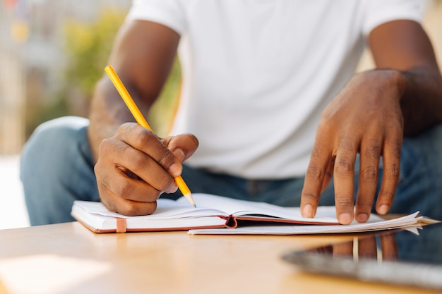 Young man sitting on a terrace and reading an article