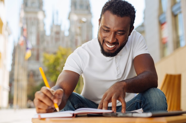 Young man sitting on a terrace and reading an article