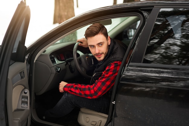 Young man sitting at the wheel of his car