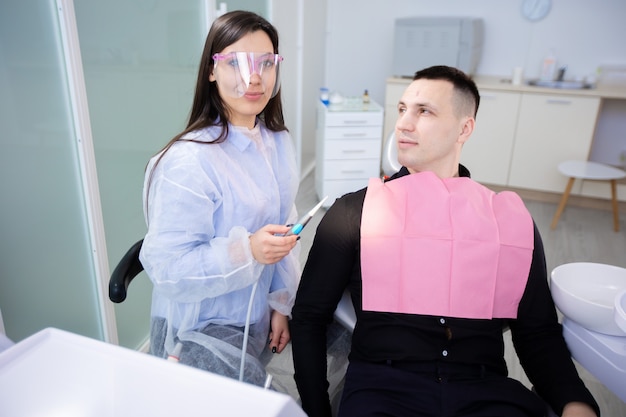 Young man sitting with female doctor in dentist's office