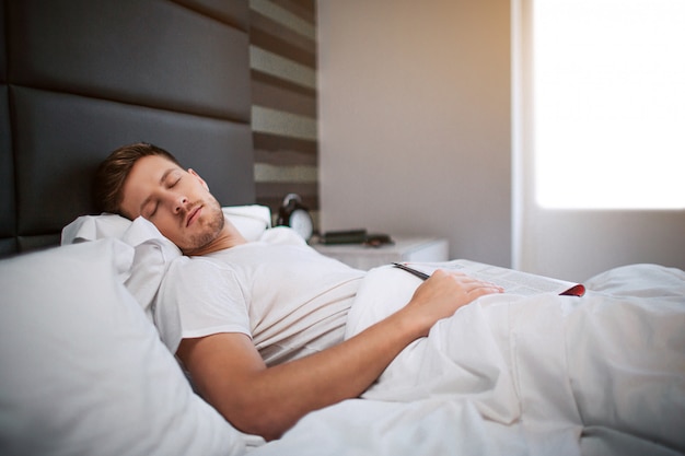 Young man sleeping in bed in the morning