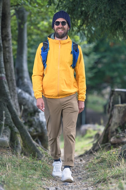 Young man smiles walks on nature trail