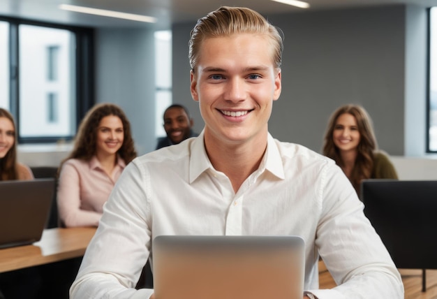 A young man smiles while using his laptop in a classroom he appears engaged and happy with students