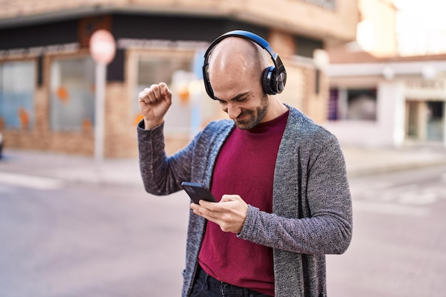 Young man smiling confident listening to music at street