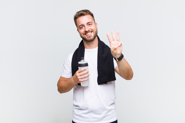 Young man smiling and looking friendly, showing number one or first with hand forward, counting down