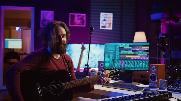 Young man songwriter playing guitar and creating music