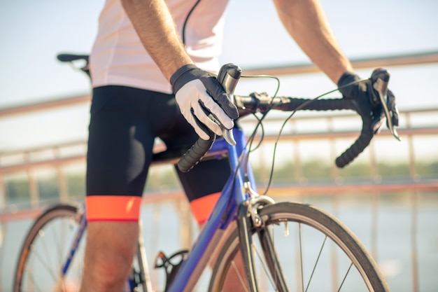 Young man in sportive clothes with a bike