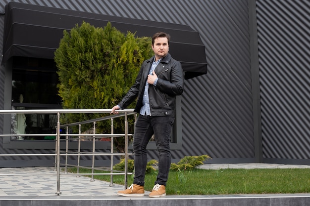 Young man standing on the background of office buildings