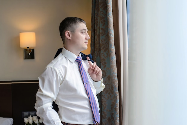 Young man standing by the window