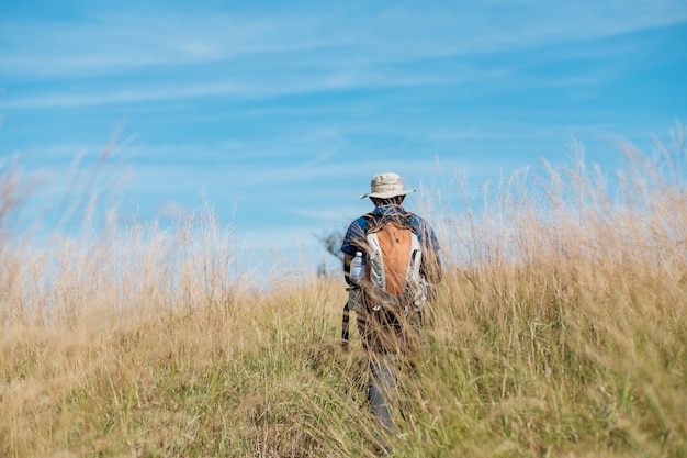 Young man standing in a grassy field Bright blue sky