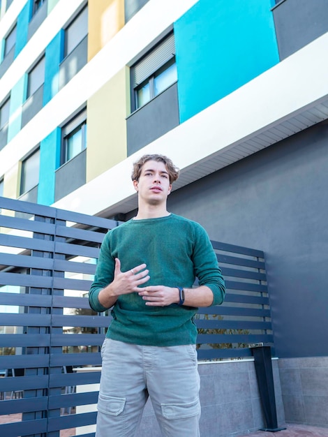 Young man standing near modern residential building