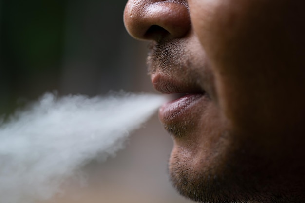 A young man standing smoking a cigarette Concept and Ideas for quitting smokingclose up