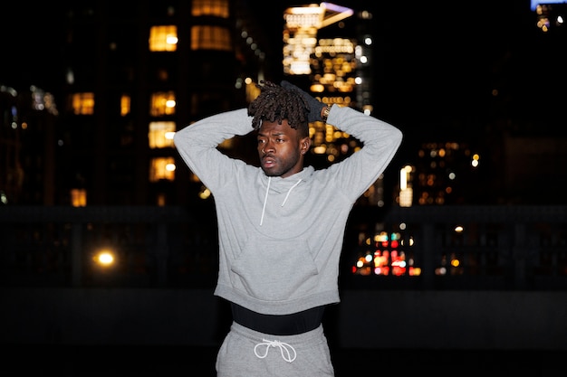 Young man stretching at night in the city