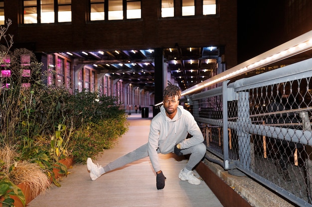 Young man stretching at night in the city