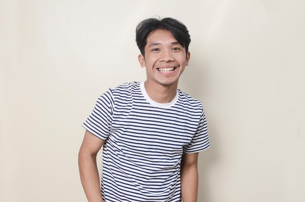 Young man in striped shirt with happy expression on isolated background