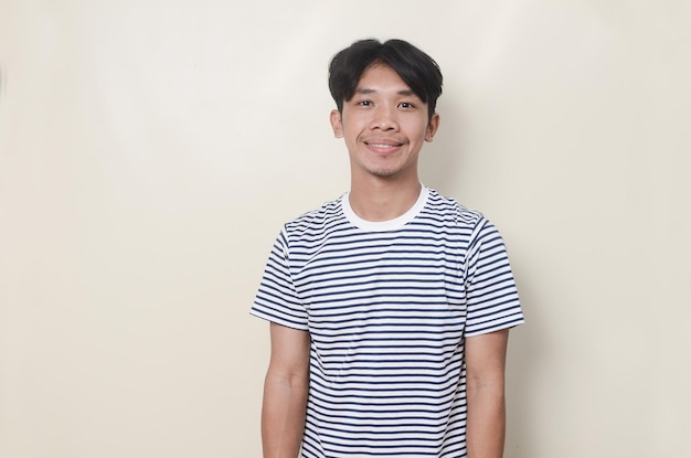 Young man in striped shirt with smiling expression on isolated background