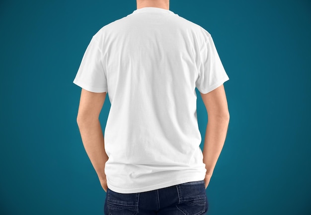 Young man in stylish tshirt on color background Mockup for design