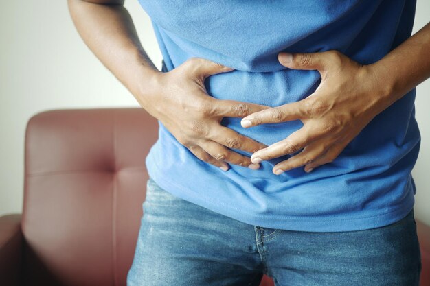 Young man suffering stomach pain close up