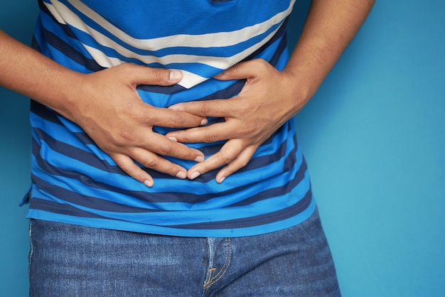 Young man suffering stomach pain close up