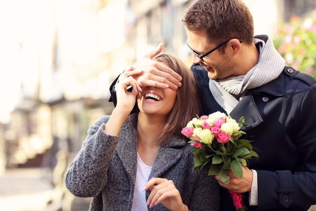 young man surprising woman with flowers