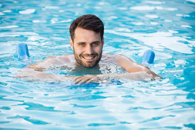 Young man swimming with inflatable tube in the pool