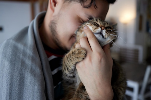 Young man in t shirt holding a cat.