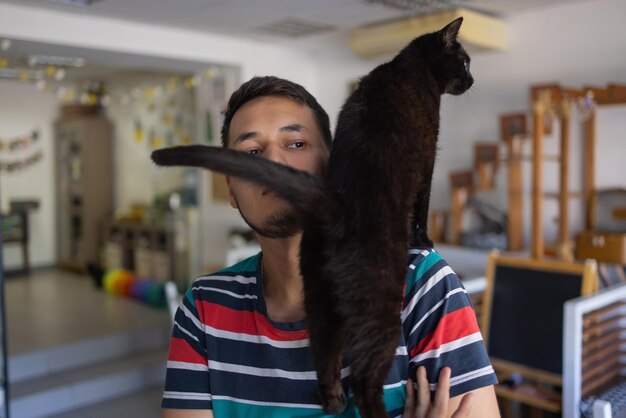 Young man in t shirt holding a cat