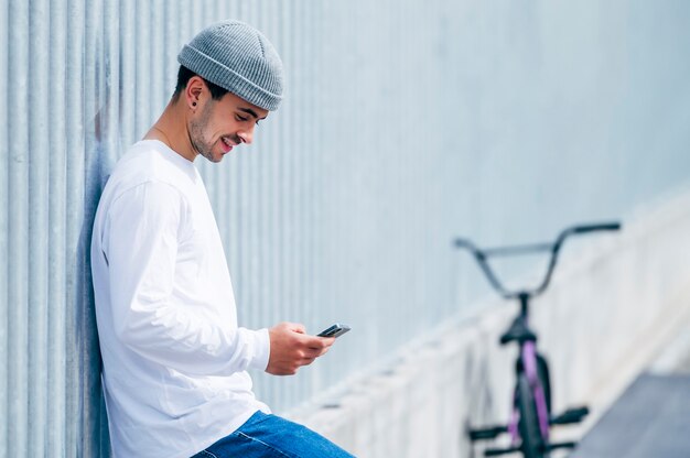 Young man taking a photo with smartphone with his bicycle