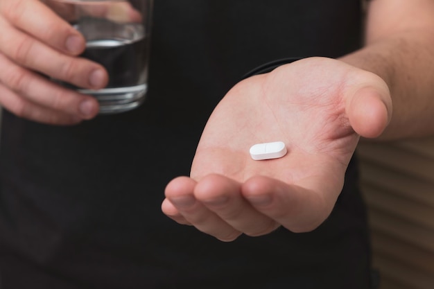 Young man taking pill at home