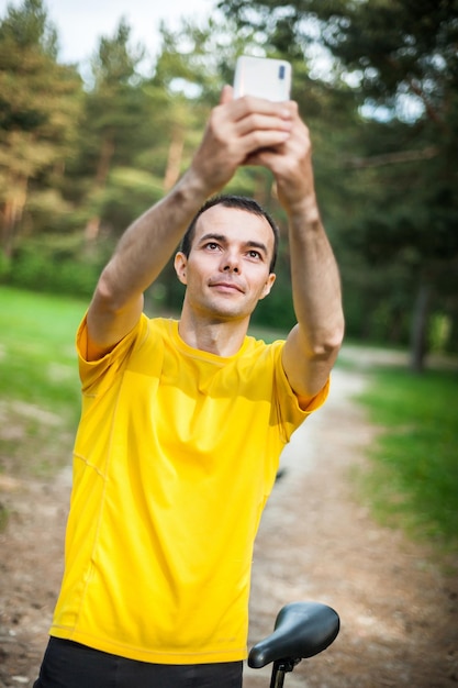 A young man taking a selfie with his Bicycle