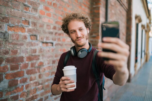 Photo young man taking selfies with phone.