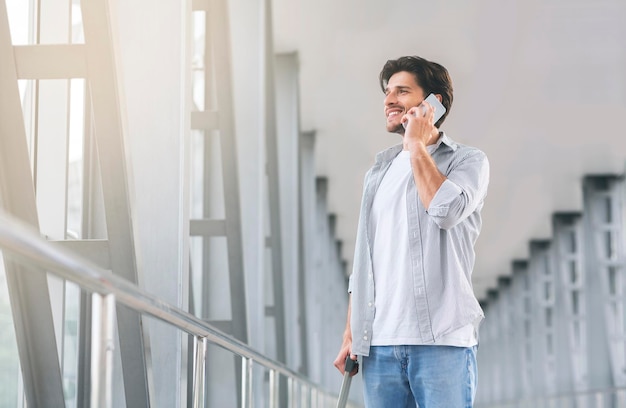 Young man talking on phone in airport terminal