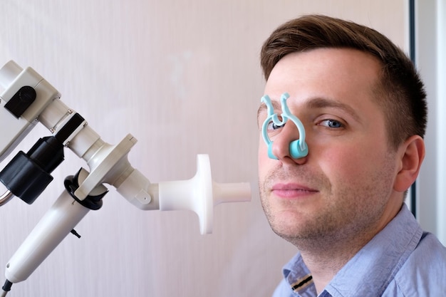 Young man testing breathing function by spirometry