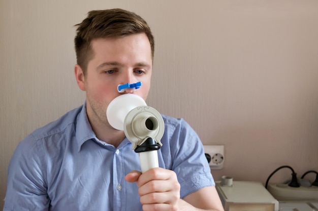 Photo young man testing breathing function by spirometry